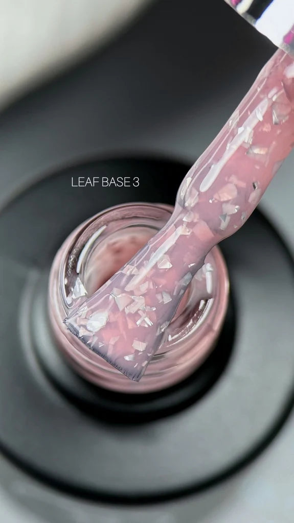 A hand applies pink nail polish using a brush, showcasing the vibrant color and precise application technique.